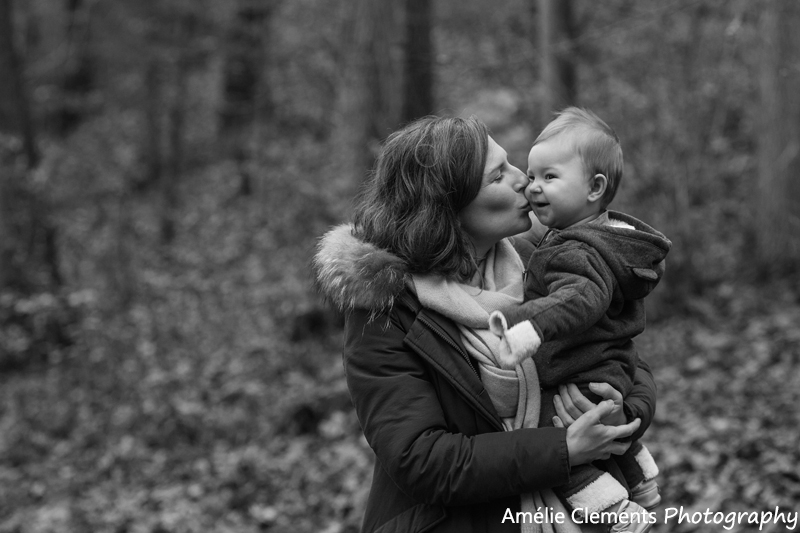 family-photographer-zurich-baby-switzerland-winter-forest-photosession-amelie-clements-photography-son-mum-portrait-kiss-black-white